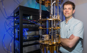 Jonathan DuBois standing next to a quantum computer