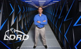 Barry Chen among racks of supercomputers