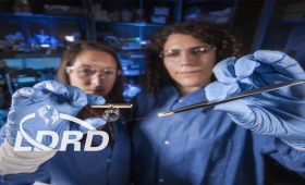 Heather Enright (left) and Anna Belle hold the brain-on-a-chip device and a microelectrode array.