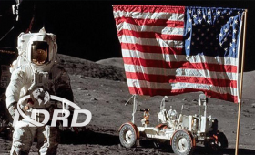 Astronaut next to American flag and rover on surface of moon