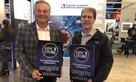 Two men holding award plaques