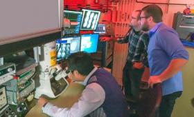 Three scientists looking at Movie Mode Dynamic Transmission Electron Microscope