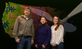 Three researchers in front of U.S. map and turbine