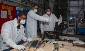 Three researchers in masks working