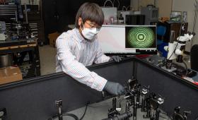 Scientist in front of tabletop bench equipment