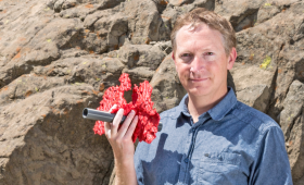 Joe Morris holding a 3D printed model of rock fractures