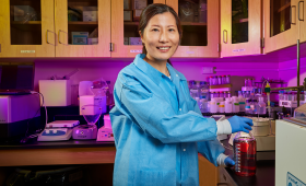 banner image of Jiao in lab holding bottle of solution