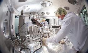 Researchers work inside metal hutch containing  sientific equipment