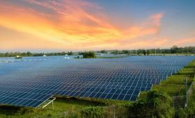 A solar farm with dozens of rows of solar panels to the horizon