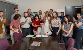 Laboratory leadership gather around table to celebrate signature.