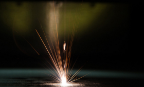Close-up of the surface of laser powder bed fusion (LBPF), a metal additive manufacturing (AM) process where a laser uses heat to fuse metal powder material and form structures.