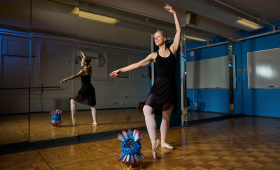 Heather Whitley in ballet studio with model of NIF target chamber on the floor