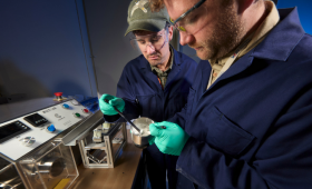 LLNL scientists Dylan Kline (front) and Justin McAlister evaluate finished, mock high-explosive materials produced using a modern pharmaceutical manufacturing process called extrusion-spheronization. 